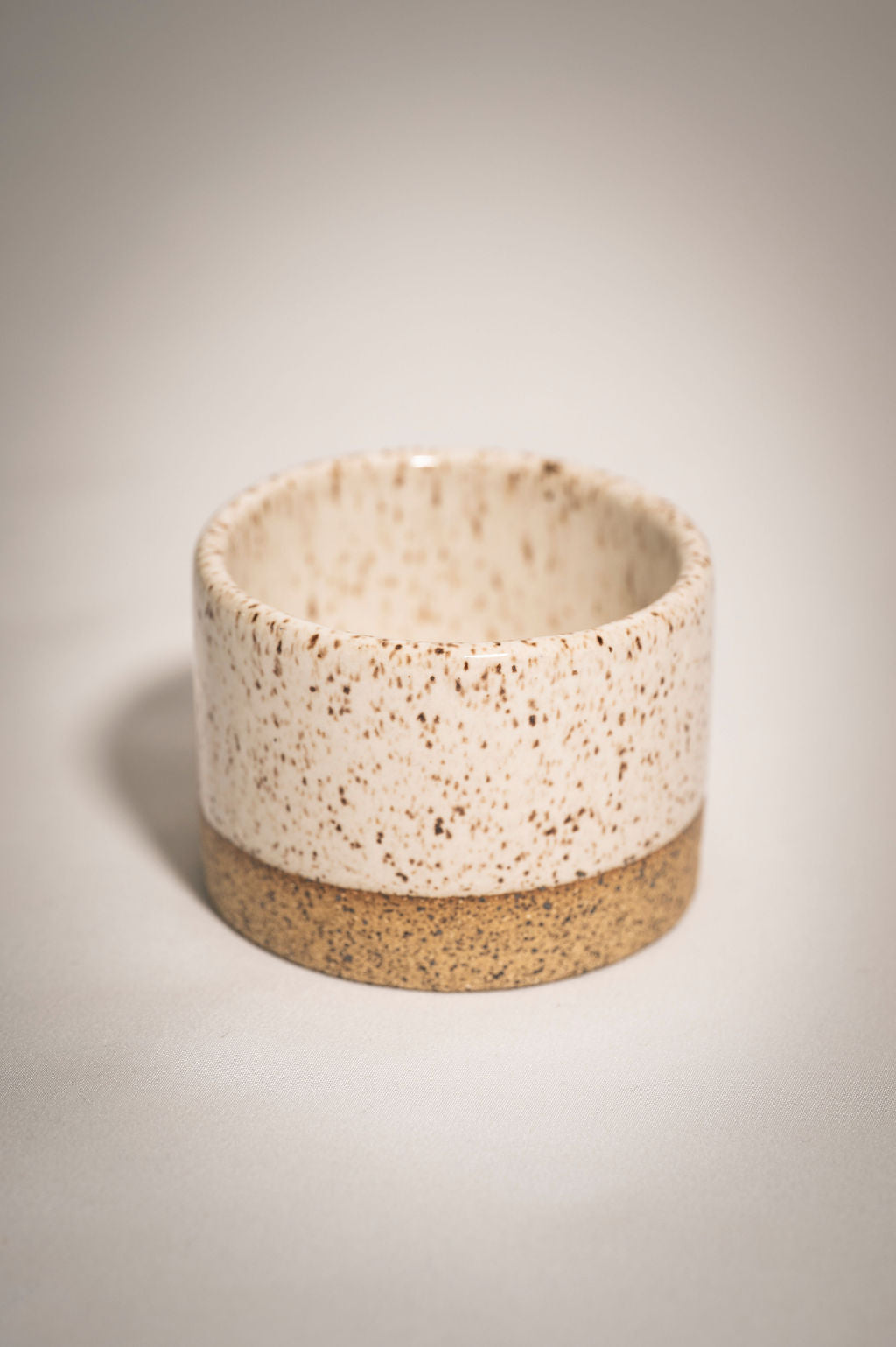 Speckled white ceramic ramekin.