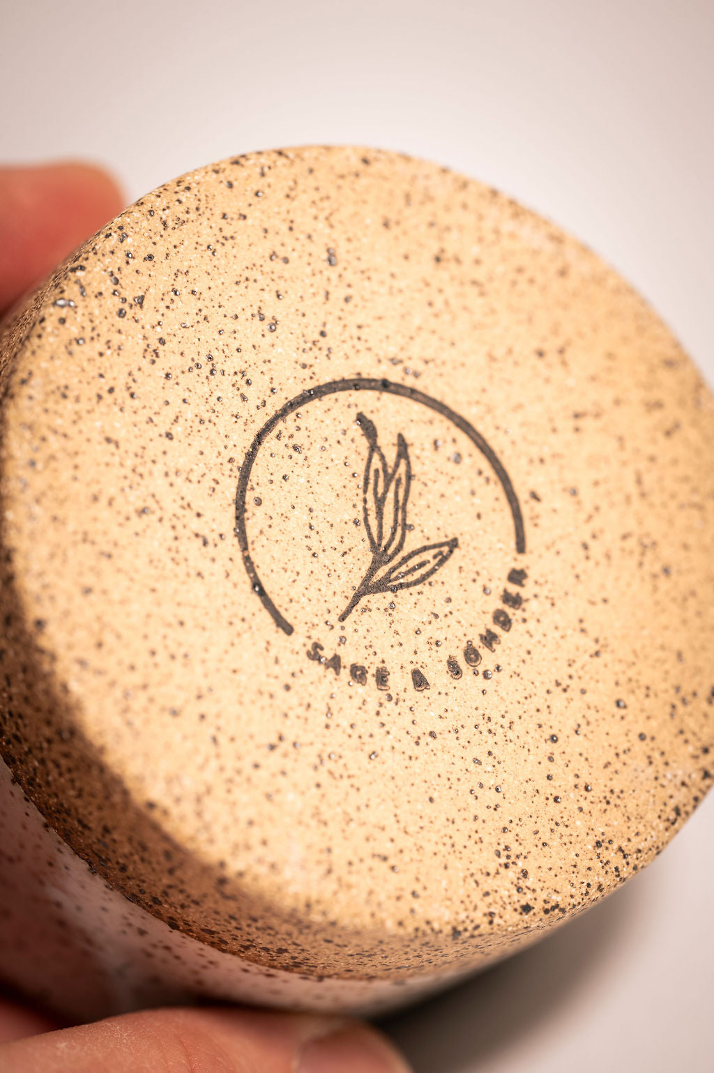 Close-up of bottom of ceramic ramekin showing a logo.