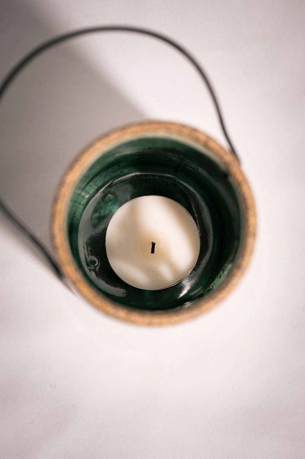 Close-up of a white tealight candle in the ceramic lantern.