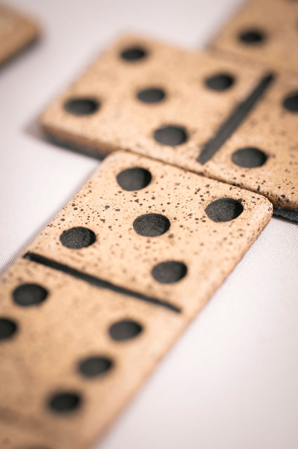 Close-up of dominoes with a speckled surface and black dots on a white background