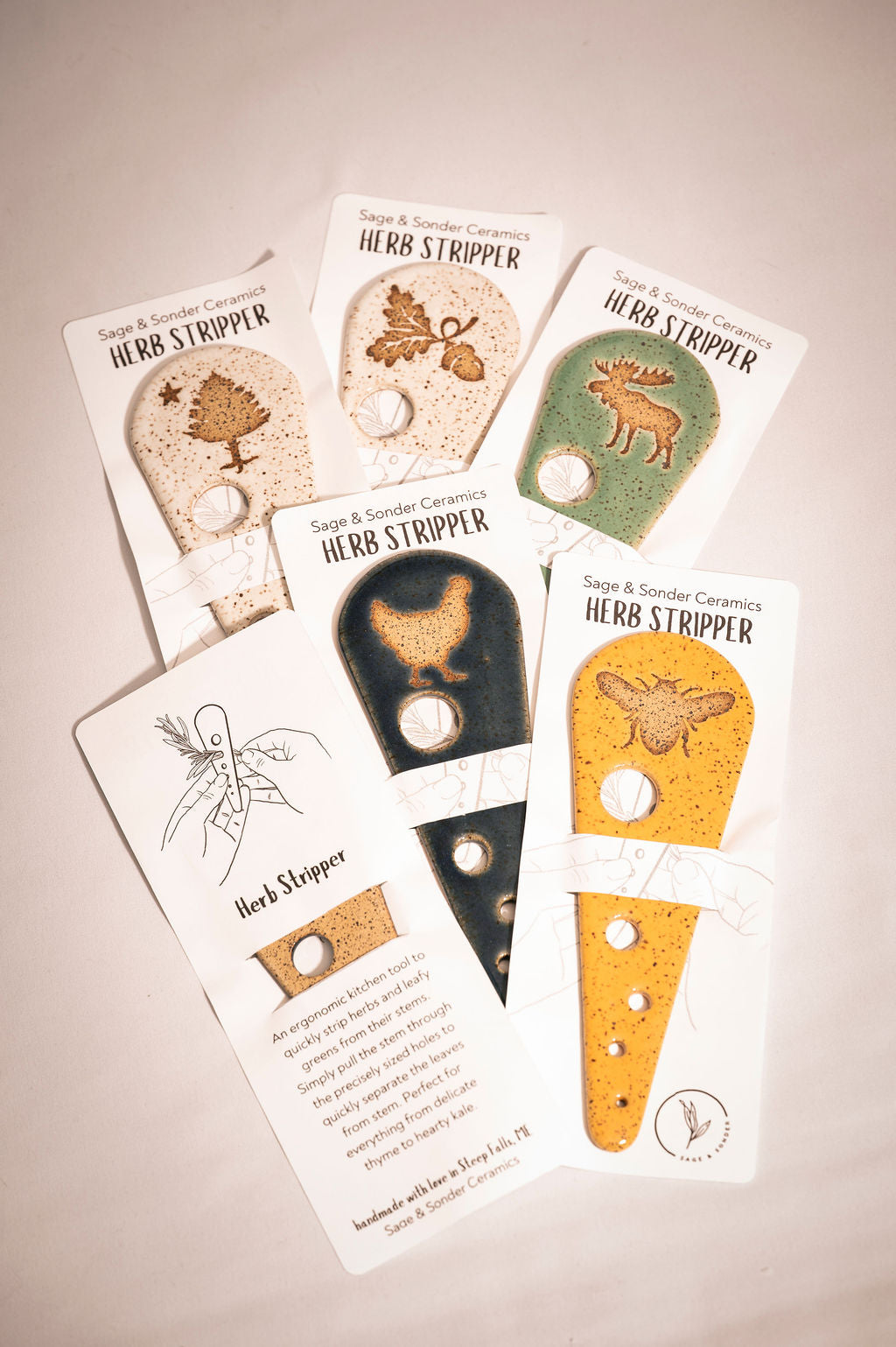 Set of herb stripper tools packaged on white cards with illustrations on a beige background